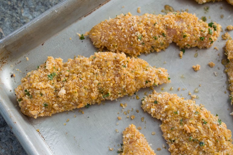 Crazy mixed-up oven fried chicken fingers are coated with a secret crumb mixture and ready to go into the oven.