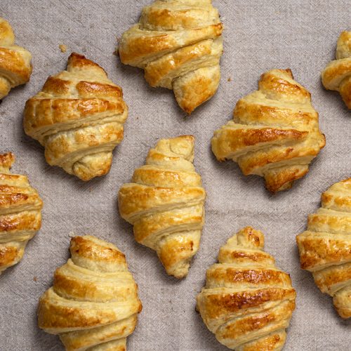 baked golden plant-based croissants on a baking sheet with parchment paper