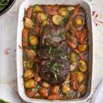 sous vide pot roast in a baking dish with vegetables and gravy
