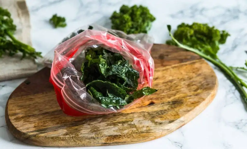 bag of frozen kale on a wooden cutting board