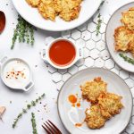 air fryer hash browns on a white round dinner plate with hot sauce